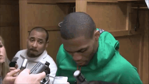 Man In Green Hoodie Being Interviewed By Group GIF