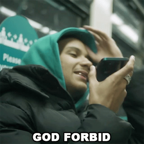 Man in Green Hoodie Holding Cell Phone Says God Forbid
