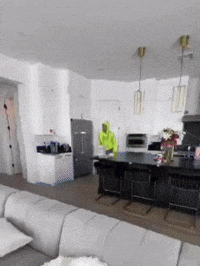 Man in Green Hoodie in Living Room and Kitchen