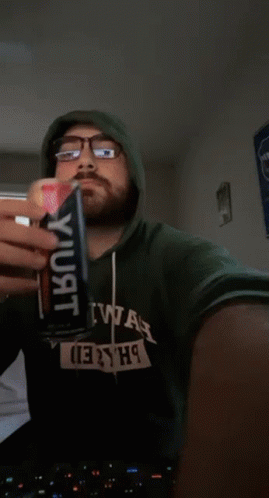 Man in Green Hoodie Saying 2hiwah Drinking From Can