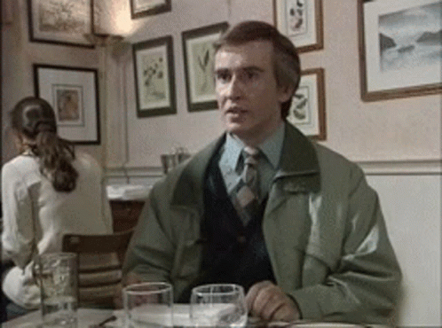 Man In Green Jacket And Tie At Table GIF