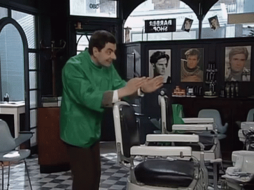 Man In Green Jacket In Front Of Barber Chair GIF