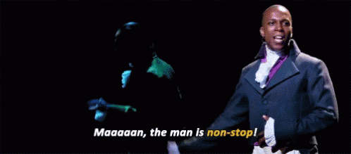 Man In Green Jacket Next To Man In Suit On Stage GIF