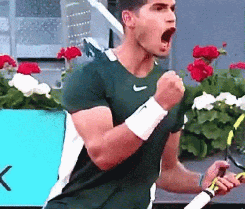 Man in Green Nike Shirt Celebrating Tennis Racquet