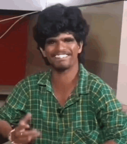 Man in Green Plaid Shirt Smiling and Pointing