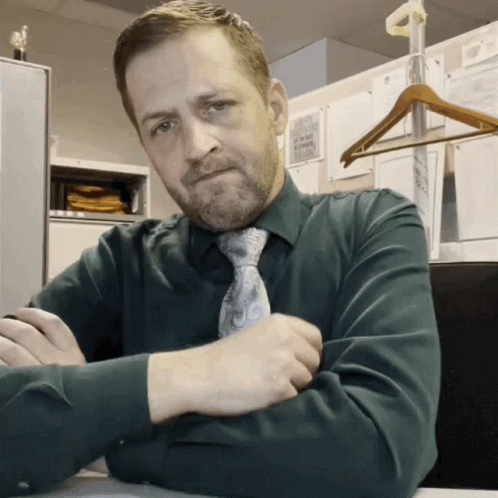 Man in Green Shirt and Tie at Desk