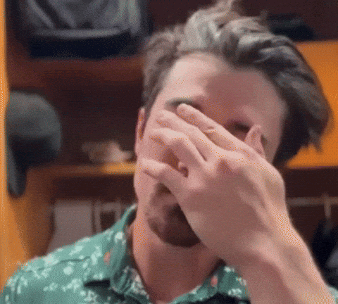 Man in Green Shirt Covering Face