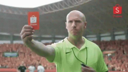 Man in Green Shirt Holding Red Card to Crowd