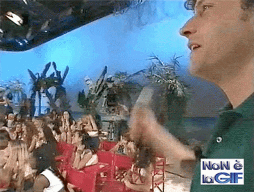Man In Green Shirt In Front Of Crowd With Sign Non E La GIF