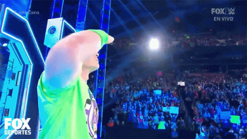 Man in Green Shirt on Stage with Fox Logo and Crowd