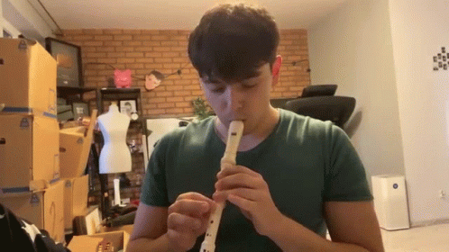 Man in Green Shirt Playing Recorder