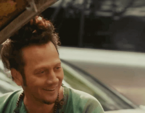 Man in Green Shirt Smiling in Car