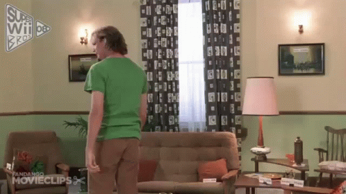 Man In Green Shirt Standing Next To Couch GIF