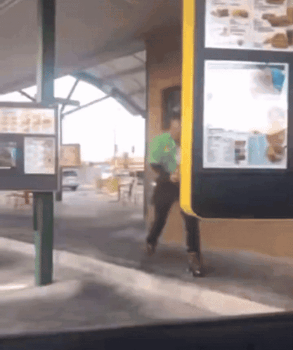 Man In Green Shirt Walking Through Drive-Thru GIF