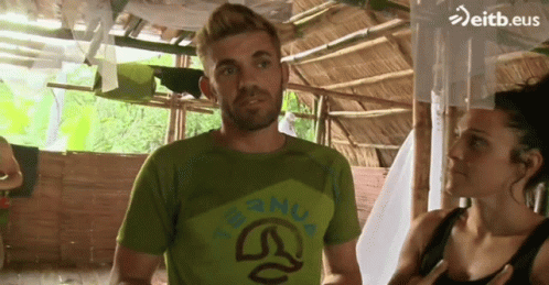 Man In Green Shirt With Nua Next To Woman GIF