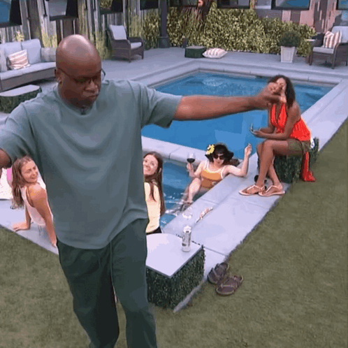 Man in Green Shirt with Women on Pool Edge