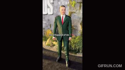 Man in Green Suit and Red Tie in Front of The Last of Us Sign