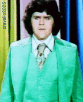 Man In Green Suit And Tie In Front Of Cravello2025 Sign GIF