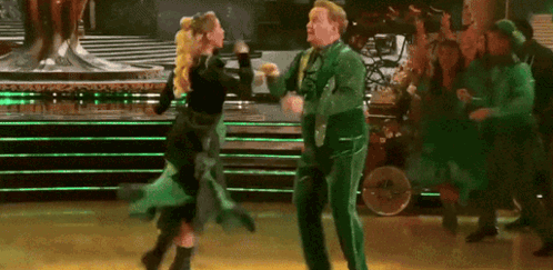 Man in Green Suit Dancing With Woman in Black Dress