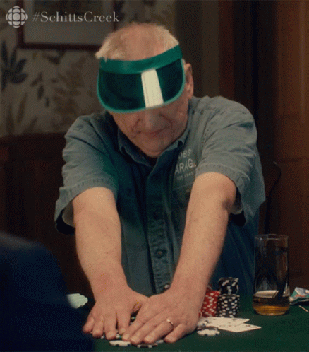 Man in Green Sun Visor Playing Poker