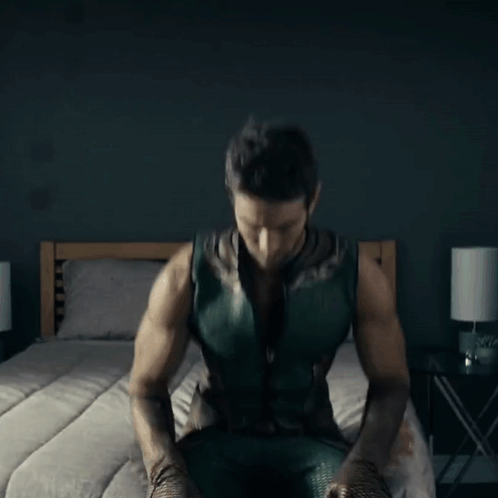 Man in Green Superhero Costume Sitting
