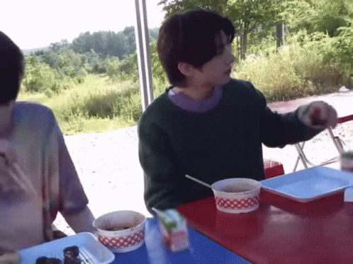 Man in Green Sweater Eating Soup