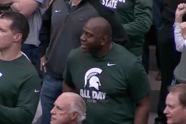 Man in Green T-Shirt With Spartan Helmet Sitting in Crowd