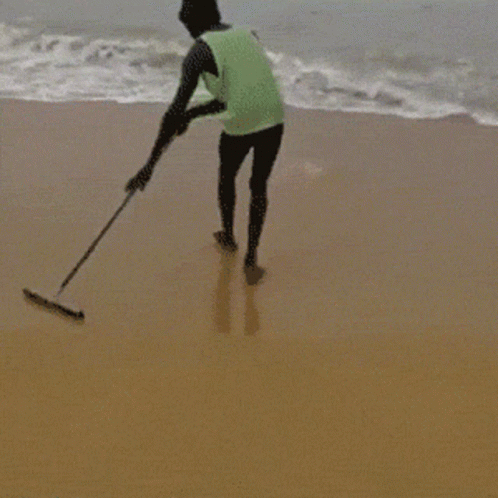 Man in Green Tank Top Standing on Beach