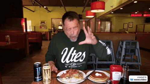 Man in Green Utes Shirt Sitting