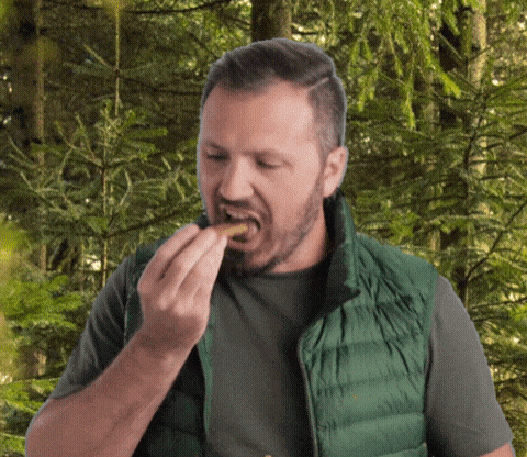 Man in Green Vest Eating Food