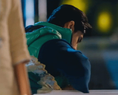 Man In Green Vest Looking Down GIF