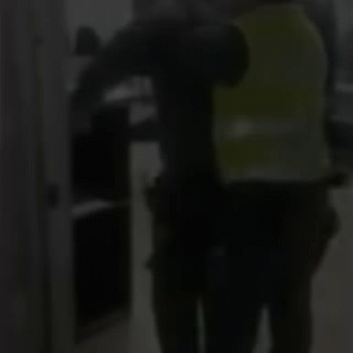 Man in Green Vest Next to Man in Black Shirt