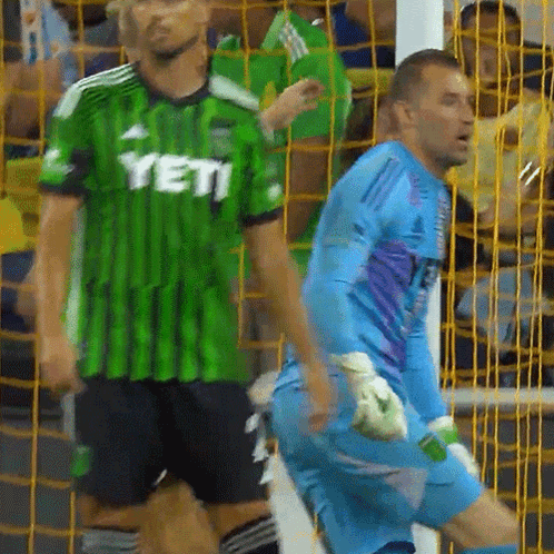 Man In Green Yeti Jersey Next To Man In Blue Jersey GIF