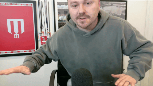 Man in Grey Hoodie at Microphone