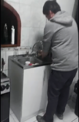 Man in Grey Hoodie Washing Dishes