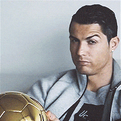 Man in Grey Jacket Holding Golden Soccer Ball