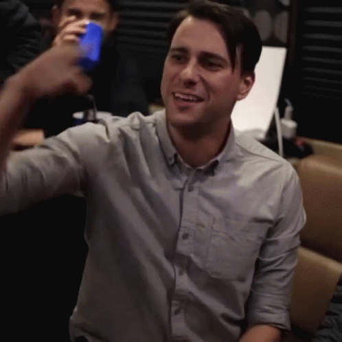 Man In Grey Shirt Holding Blue Can GIF