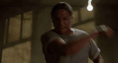 Man In Grey Shirt In Dark Room GIF