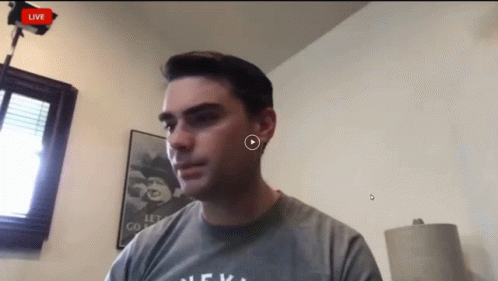 Man In Grey Shirt Looking At Camera GIF