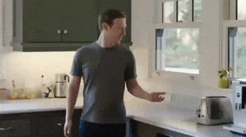 Man in Grey Shirt Next to Toaster and Window