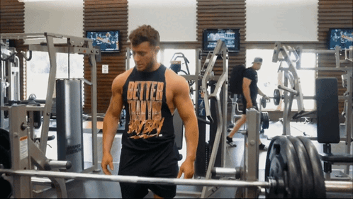 Man in Gym in Black Tank Top Saying Better Than Ever