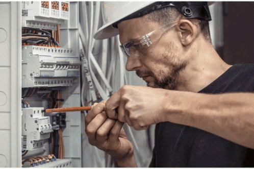 Man In Hard Hat And Safety Glasses Working On Circuit Board GIF