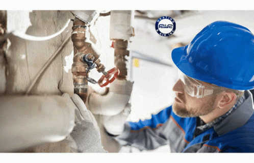 Man in Hard Hat and Safety Glasses Working on Pipe
