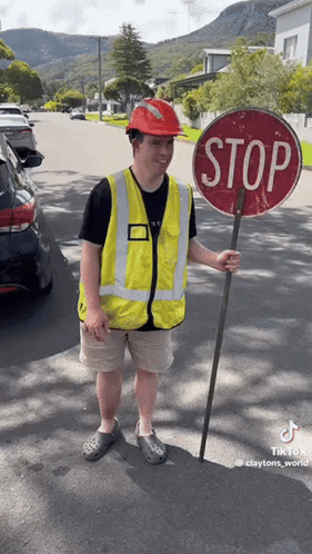 Man in Hard Hat Holding Stop Sign