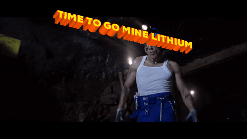Man in Hard Hat Under Lithium Sign
