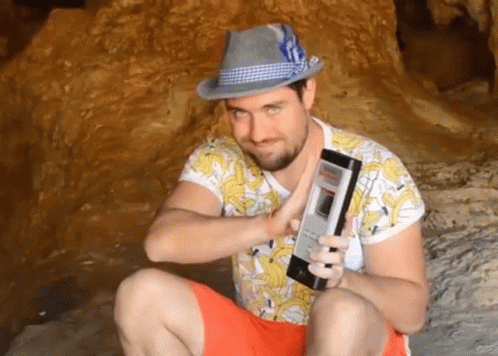 Man in Hat and Banana Shirt Holding Phone