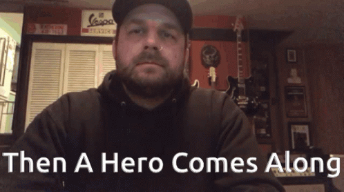 Man in Hat and Black Hoodie Saying Then a Hero Comes Along