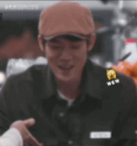 Man In Hat And Black Shirt Smiling Holding Hand GIF