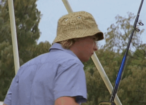 Man In Hat And Blue Shirt Holding Fishing Rod GIF