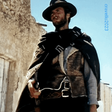 Man in Hat and Cape in Front of Building with 2003